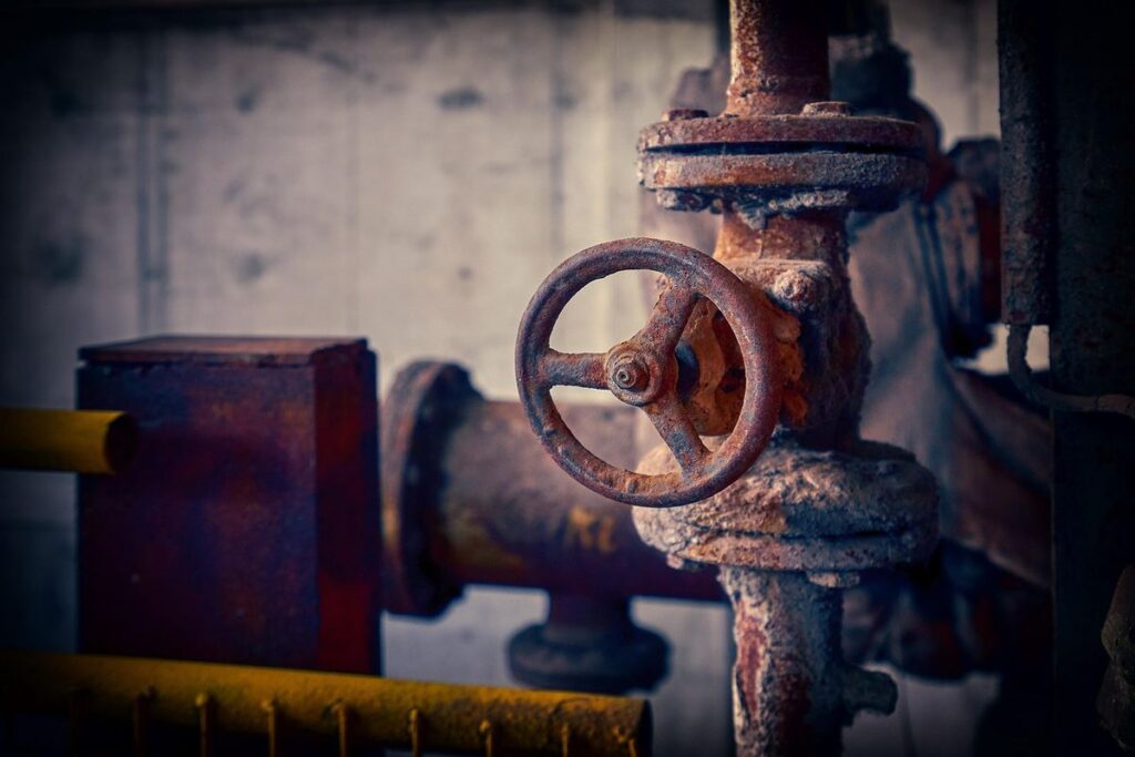 Valve rouillée et tuyauterie métallique dans un environnement d'atelier industriel