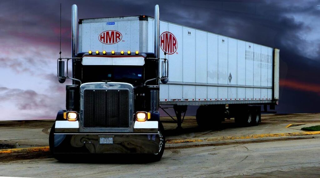 Un camion avec remorque HMR sur une route sous un ciel sombre