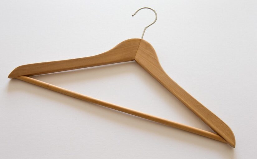 Cintre en bois suspendu, crochet métallique, fond blanc