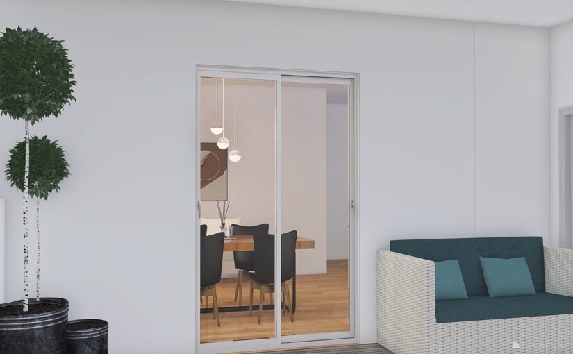 Un salon moderne avec canapé, porte vitrée ouvrant sur une salle à manger