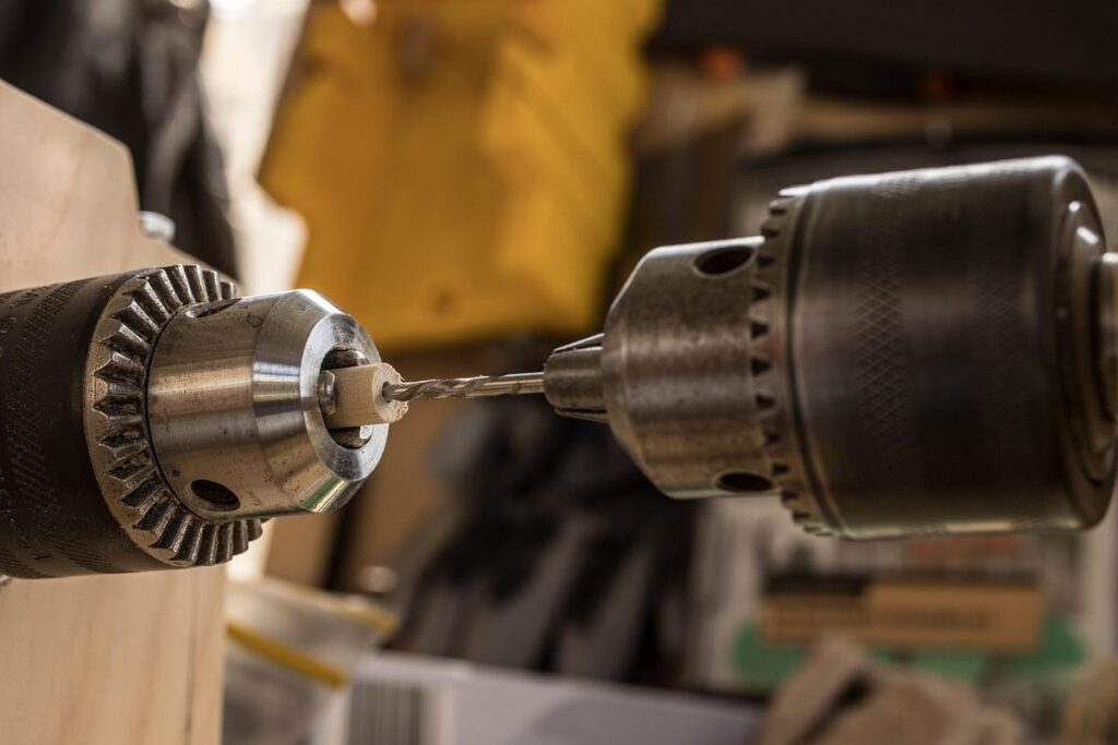 Perceuse vissant une vis dans un bois, atelier, outils autour