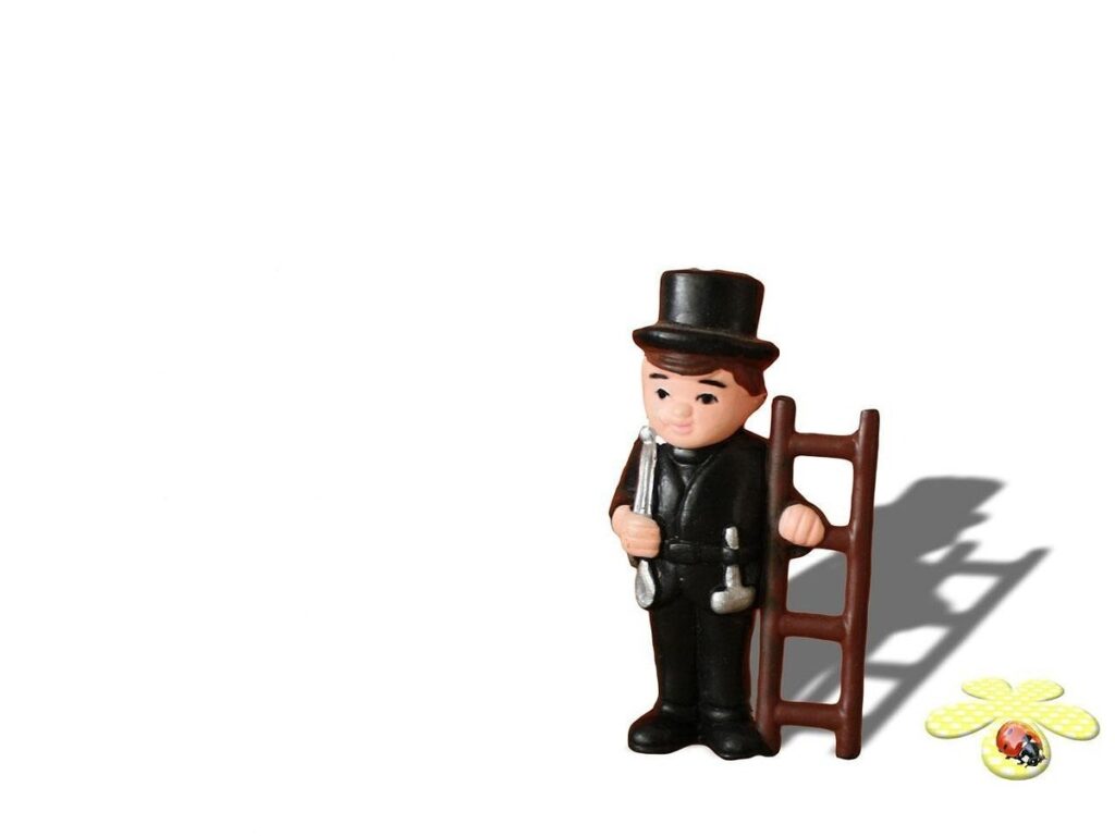 Figurine d'homme en noir avec échelle et outils, fond blanc