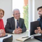 Professionnels discutant autour d'un dossier dans un environnement de bureau
