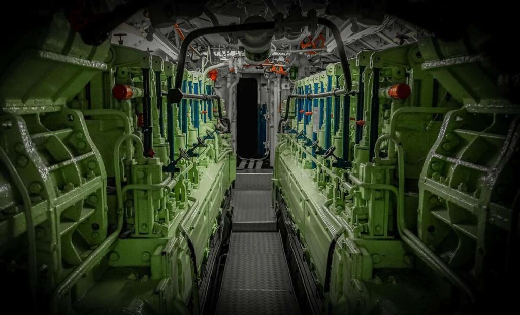 Tuyauterie isolée et moteur marin dans une salle des machines de yacht