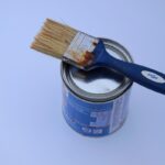 Un pot de peinture avec un pinceau posé dessus
