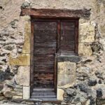 Porte en bois ancien dans un mur de pierre rustique