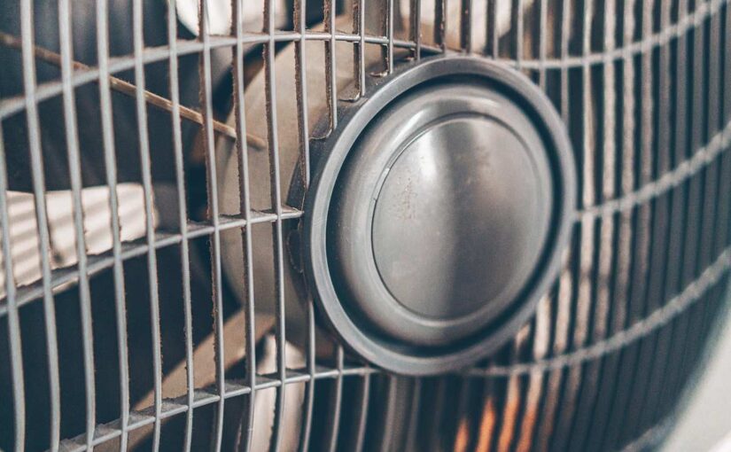 grille métallique recouvre un ventilateur en marche lame visible