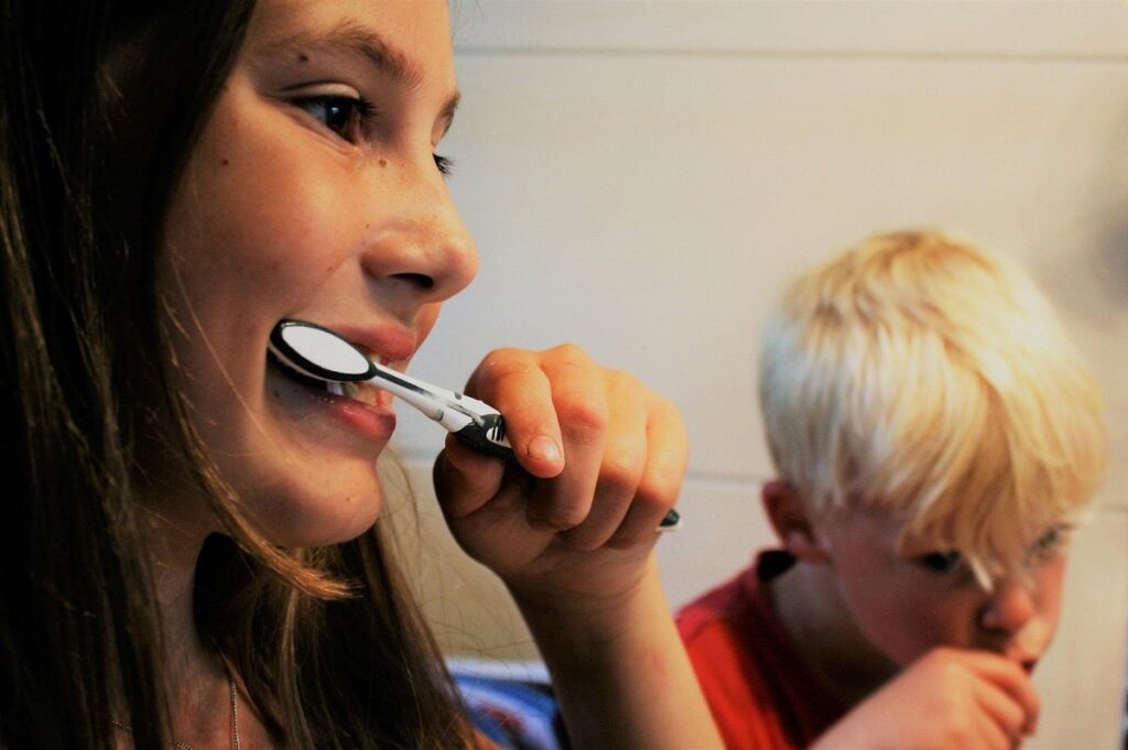Fille et garçon brossent leurs dents dans une salle de bain