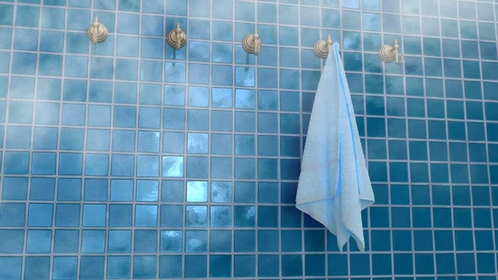Carrelage bleu avec des robinets dorés et une serviette blanche pendue dessus