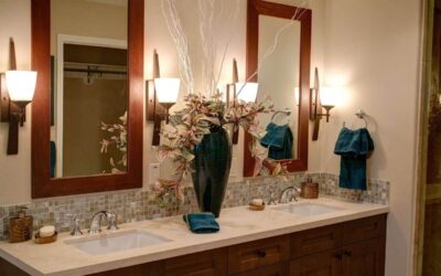 Salle de bain avec double vasque, miroirs encadrés bois, éclairage mural et carrelage
