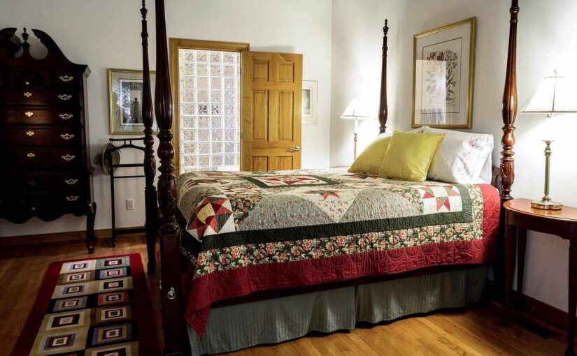 Chambre traditionnelle avec lit à baldaquin, commode, table de chevet et tapis